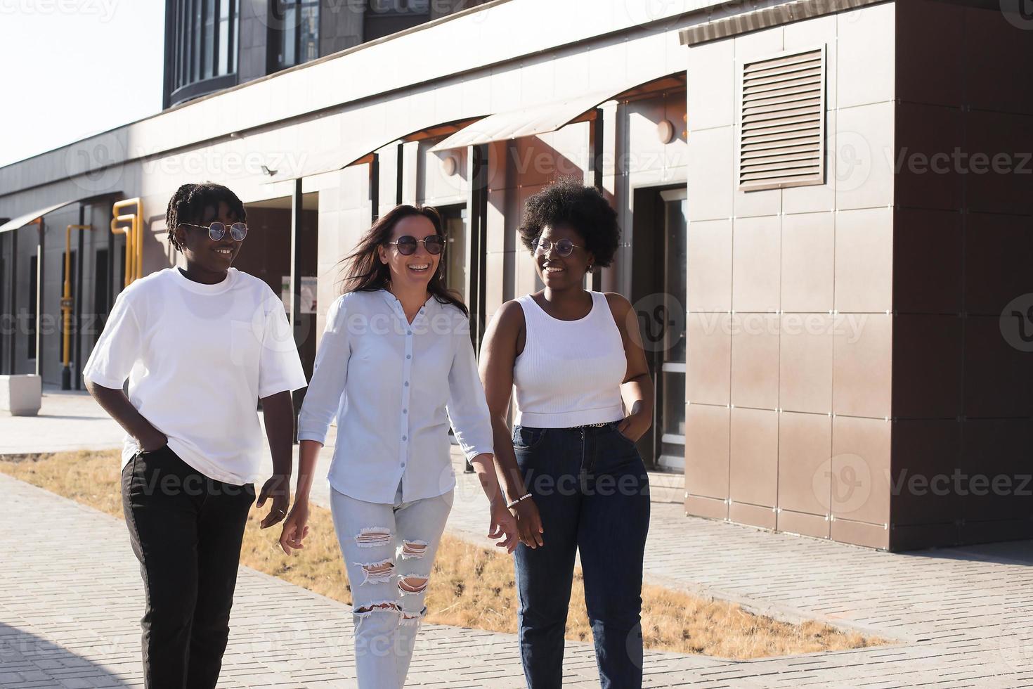 niñas felices de diferentes nacionalidades están caminando por la calle foto