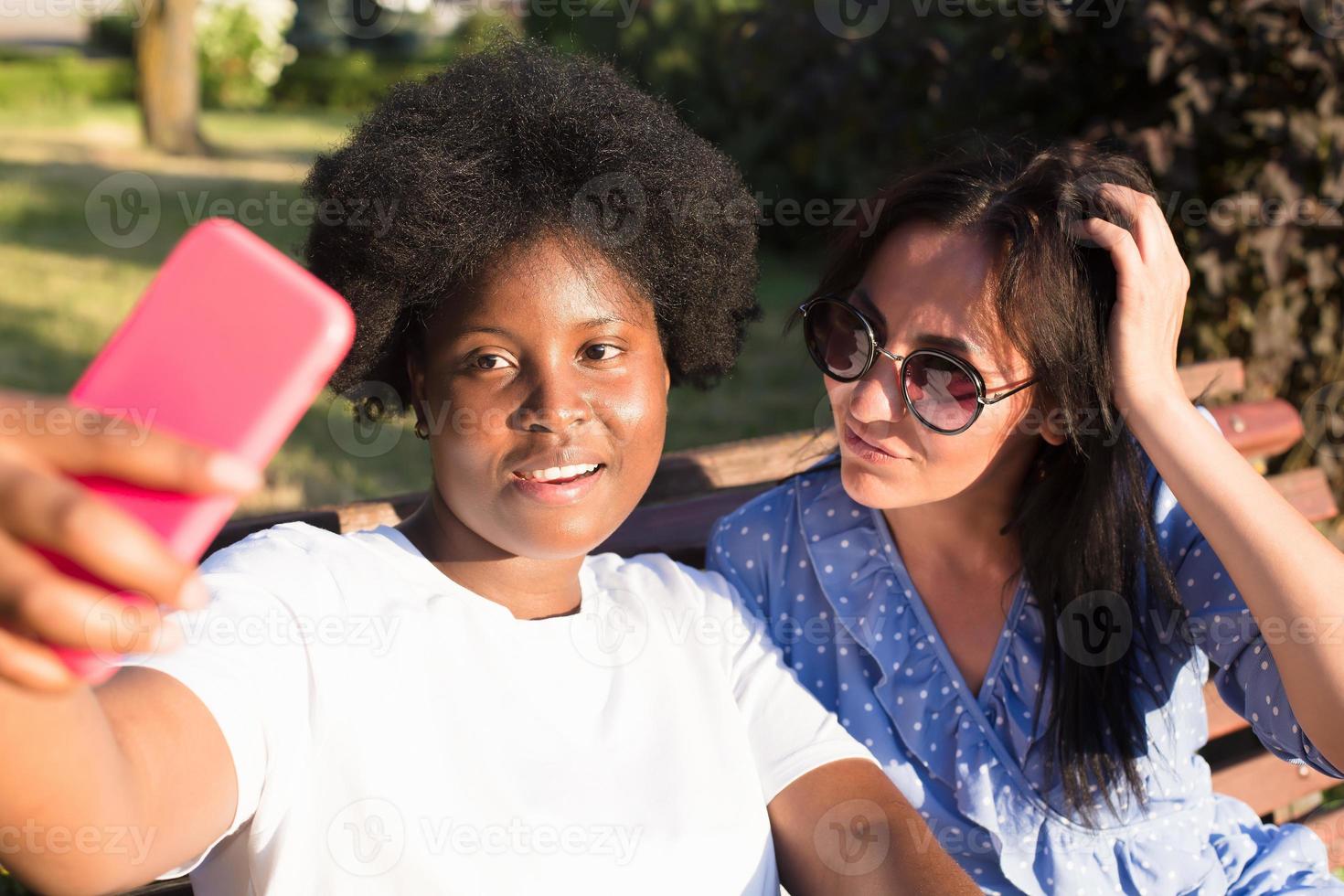 happy girls of different nationalities take selfies in the summer photo