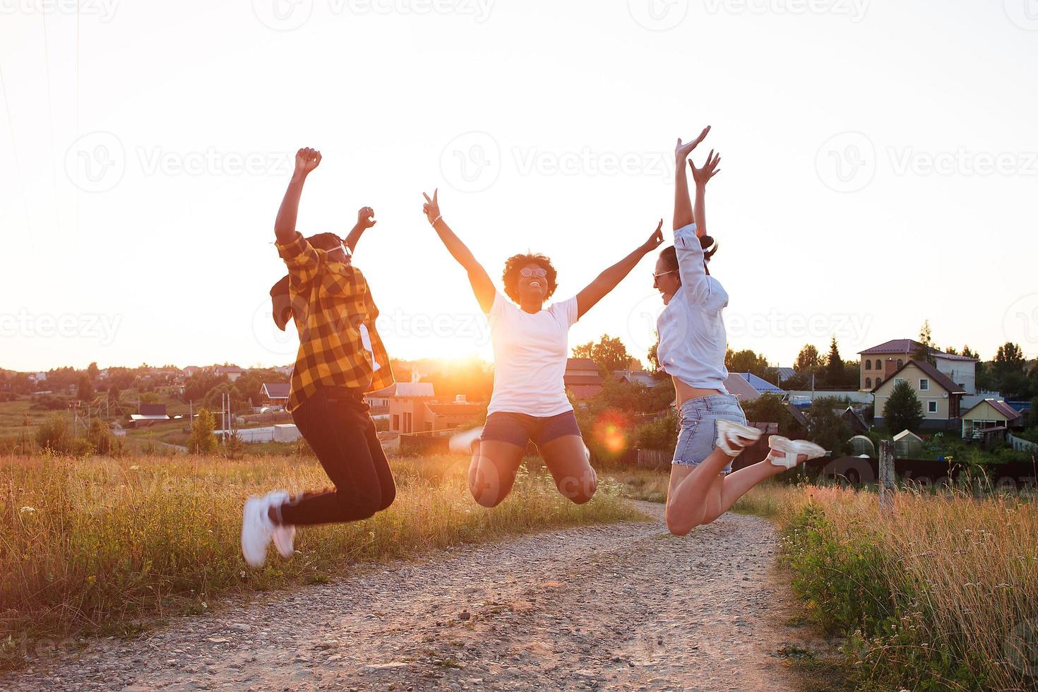 happy girls of different nationalities jump and have fun photo