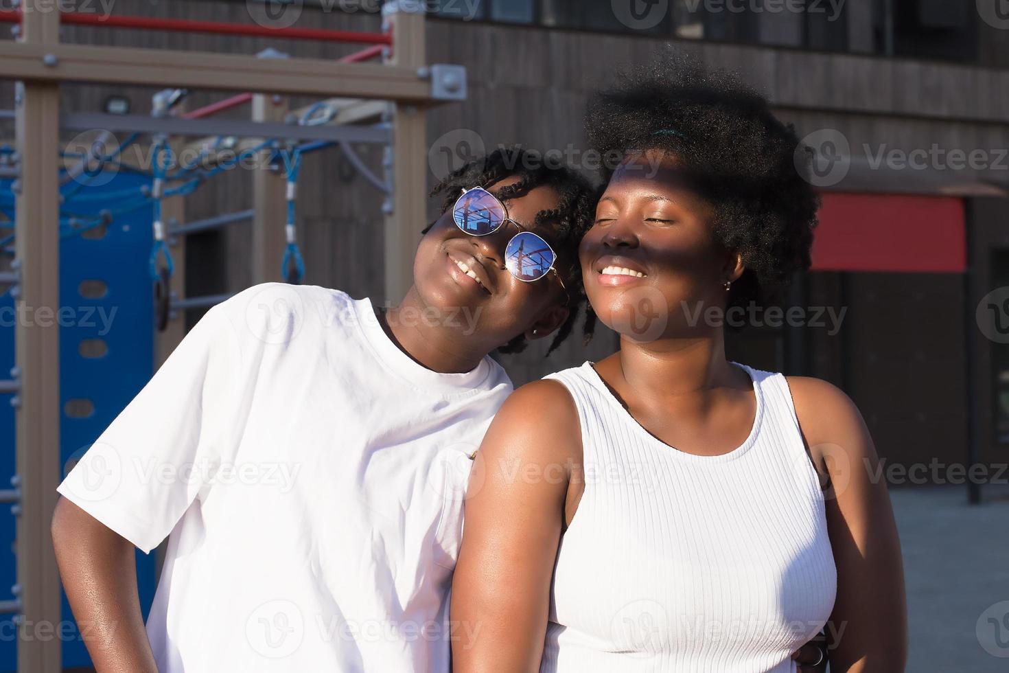 dos mujeres afroamericanas felices se comunican y se ríen en la calle foto