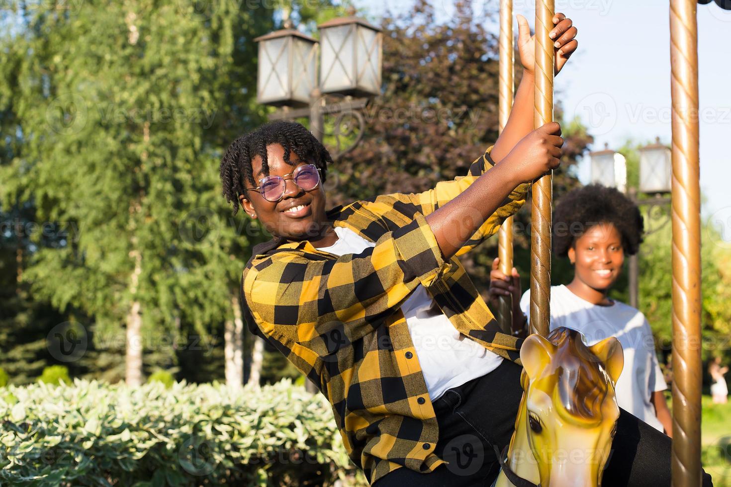 two happy African-American women in a park on an amusement ride photo