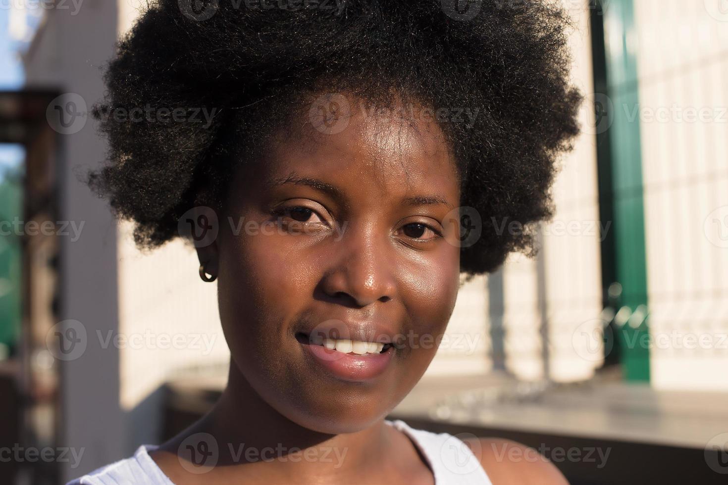 Retrato de una mujer afroamericana feliz en la calle en verano foto