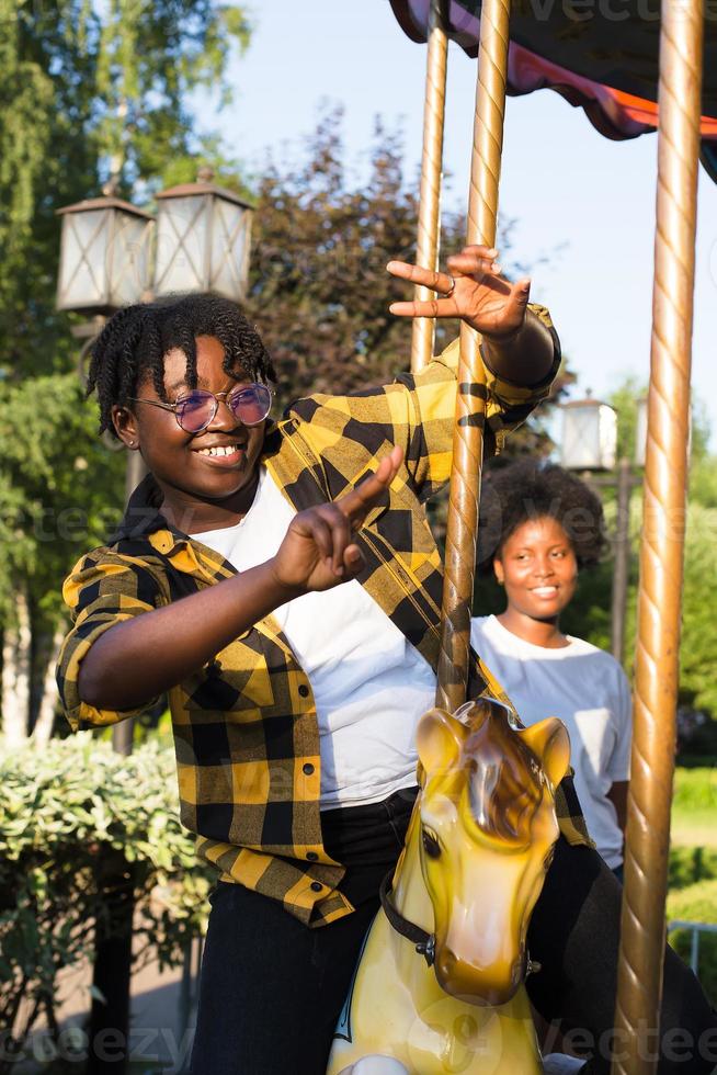two happy African-American women in a park on an amusement ride photo