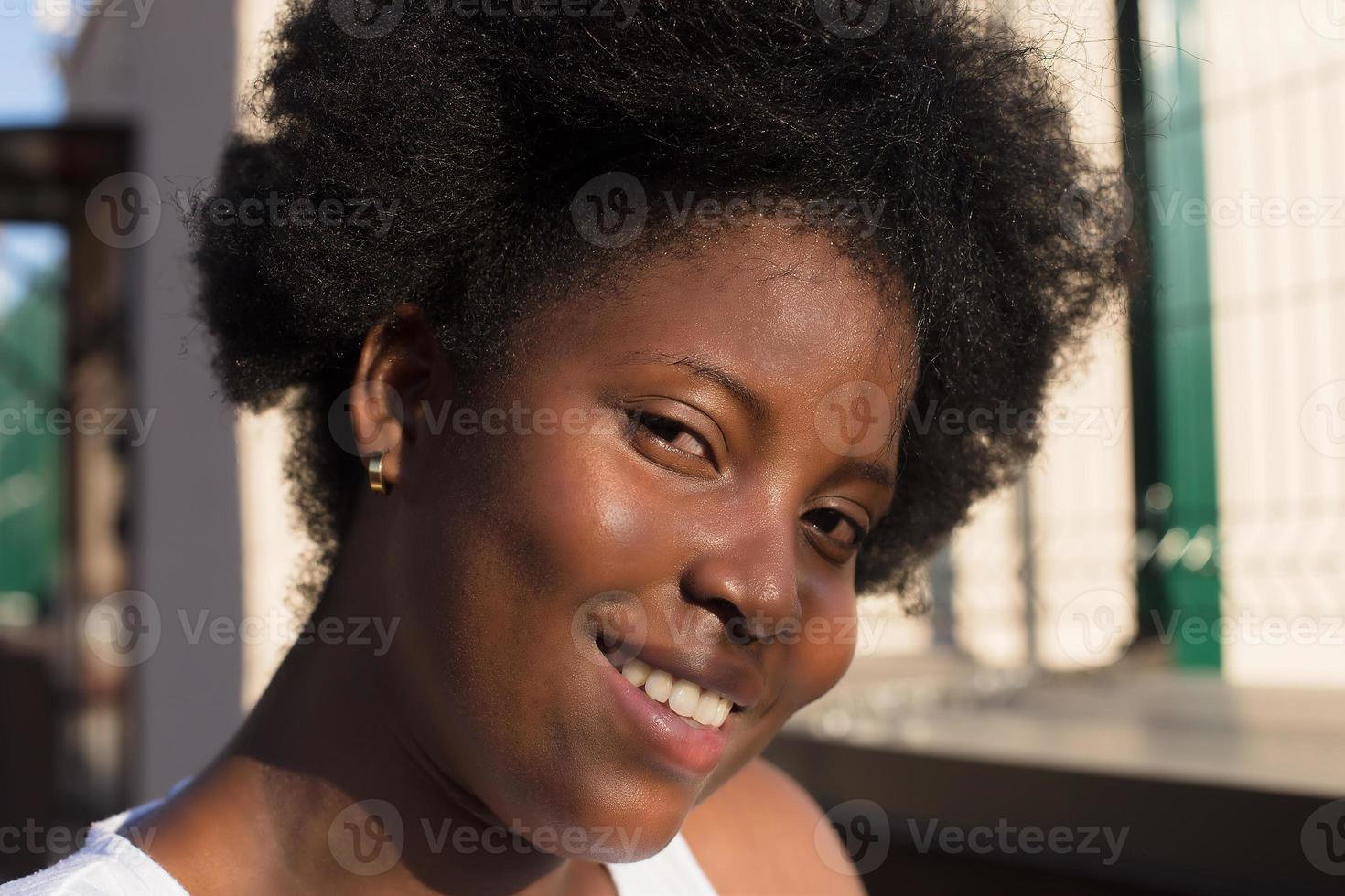 Retrato de una mujer afroamericana feliz en la calle en verano foto