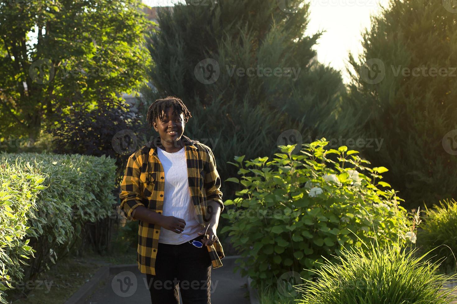 happy African American woman walks down the street in the summer photo