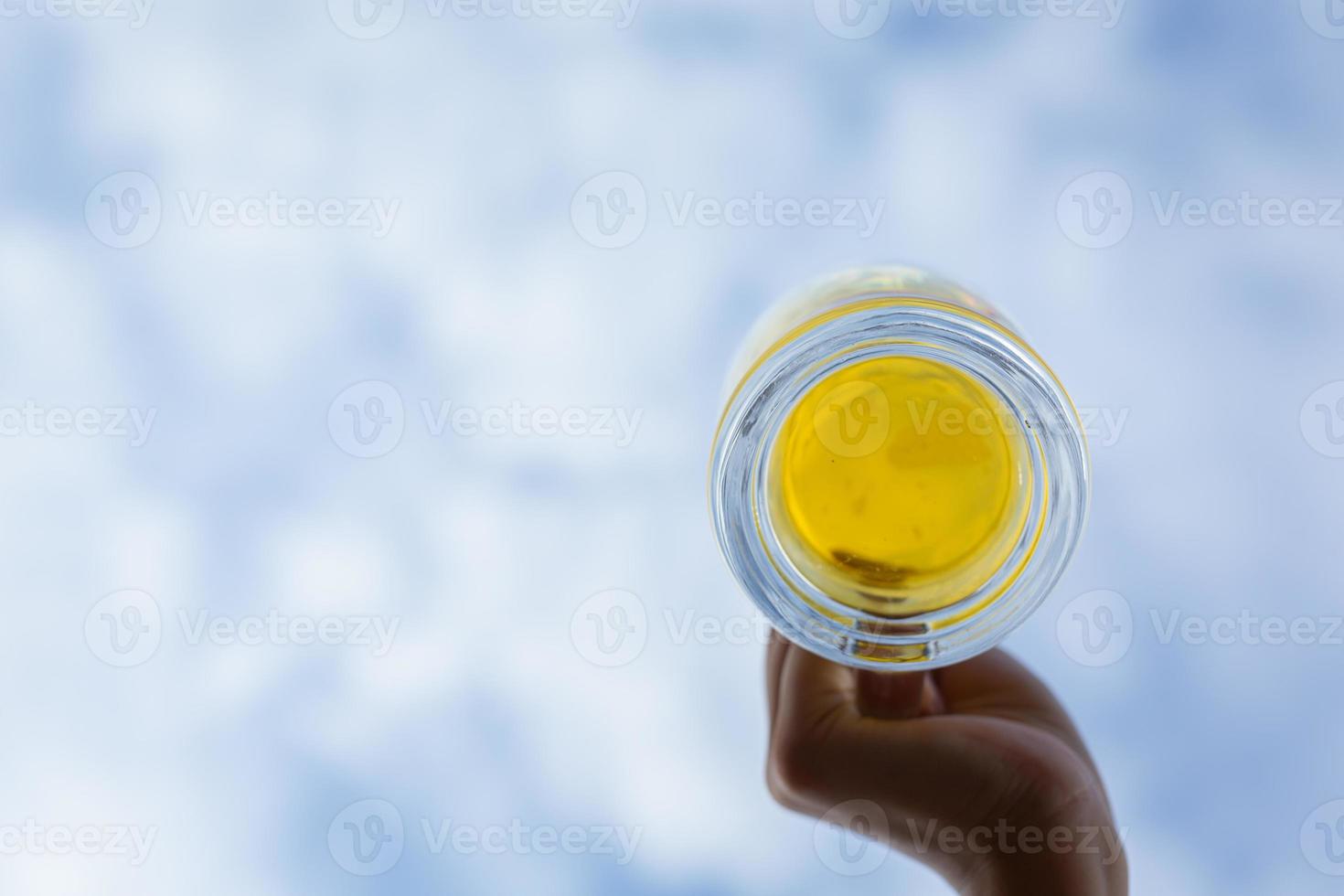 sosteniendo un vaso de cerveza en el cielo foto