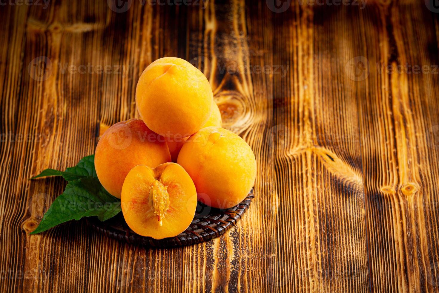 Peaches are placed on a wooden board. photo