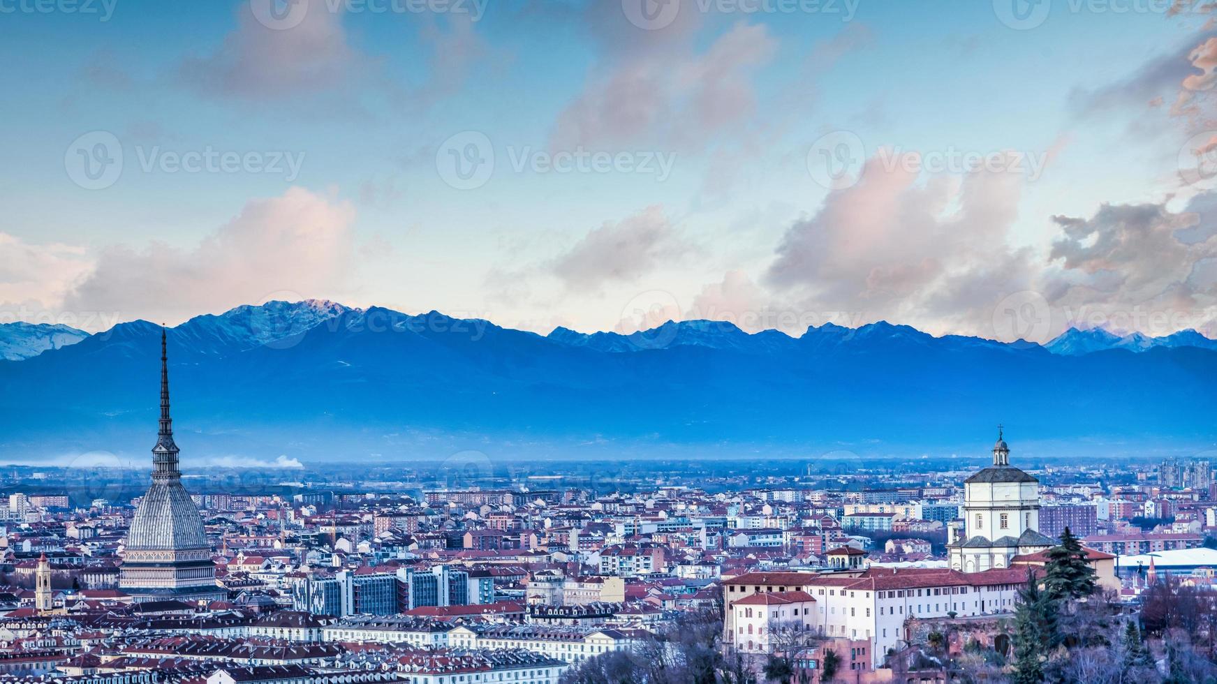 Horizonte panorámico de Turín al atardecer con los Alpes en segundo plano. foto