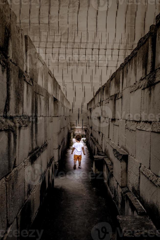 Caucasian young kid walking in a labyrinth. photo