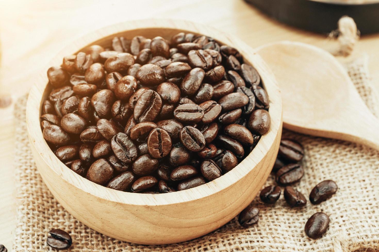 Coffee bean on wooden bowl with home made coffee background photo