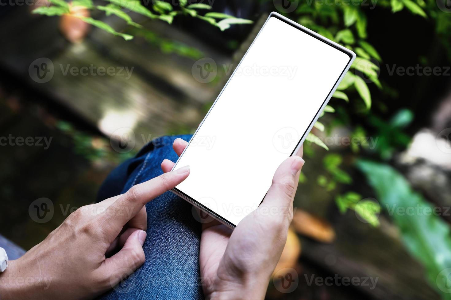 mano de mujer sosteniendo teléfono inteligente con pantalla en blanco foto