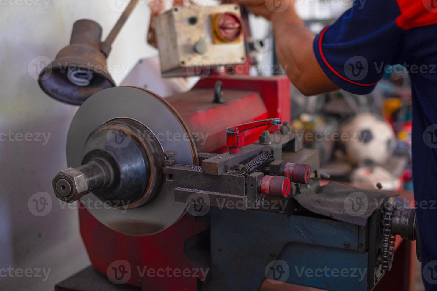 Mechanic man repairing brake use lathe tool polishing disc brakes photo