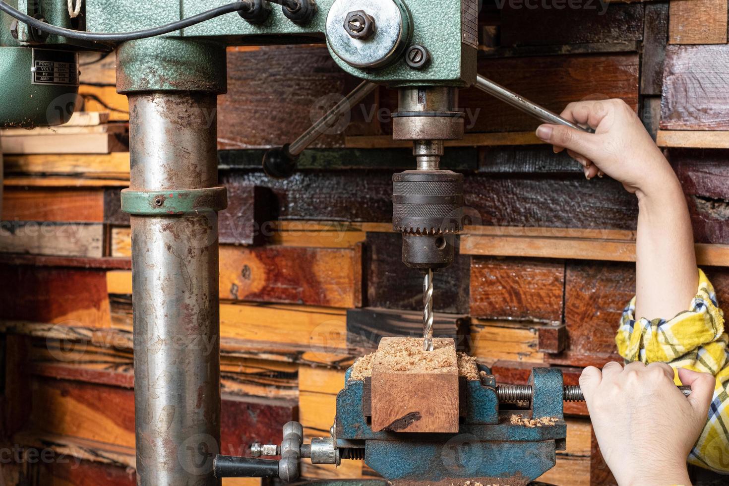 las mujeres de pie es artesanía trabajando madera de taladro foto