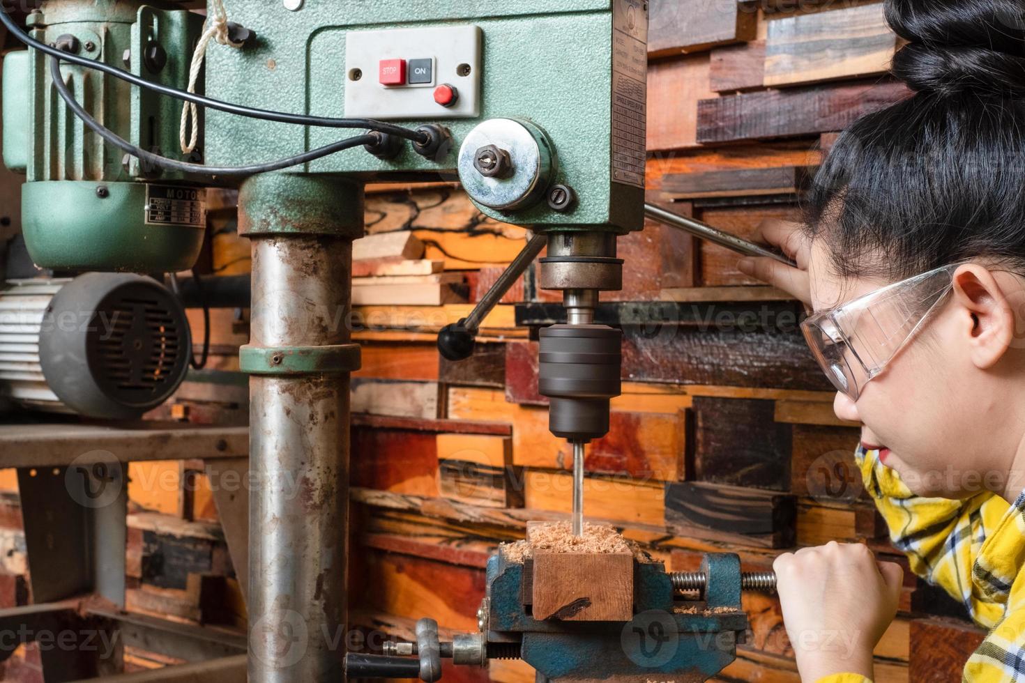 Women standing is craft working drill wood photo