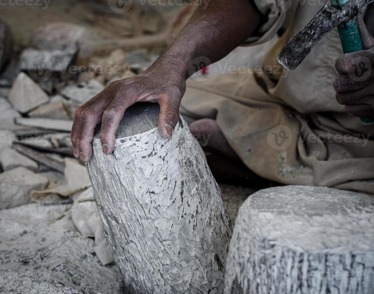 hands of a male Egyptian sculptor while working with a stone alabaster photo