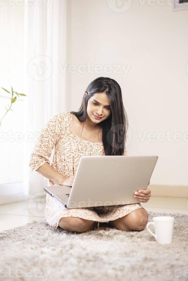 Indian pretty young girl using laptop at home photo