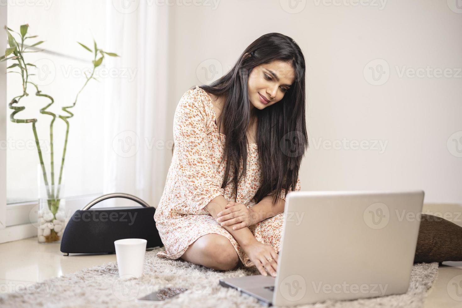 Indian pretty young girl using laptop at home photo