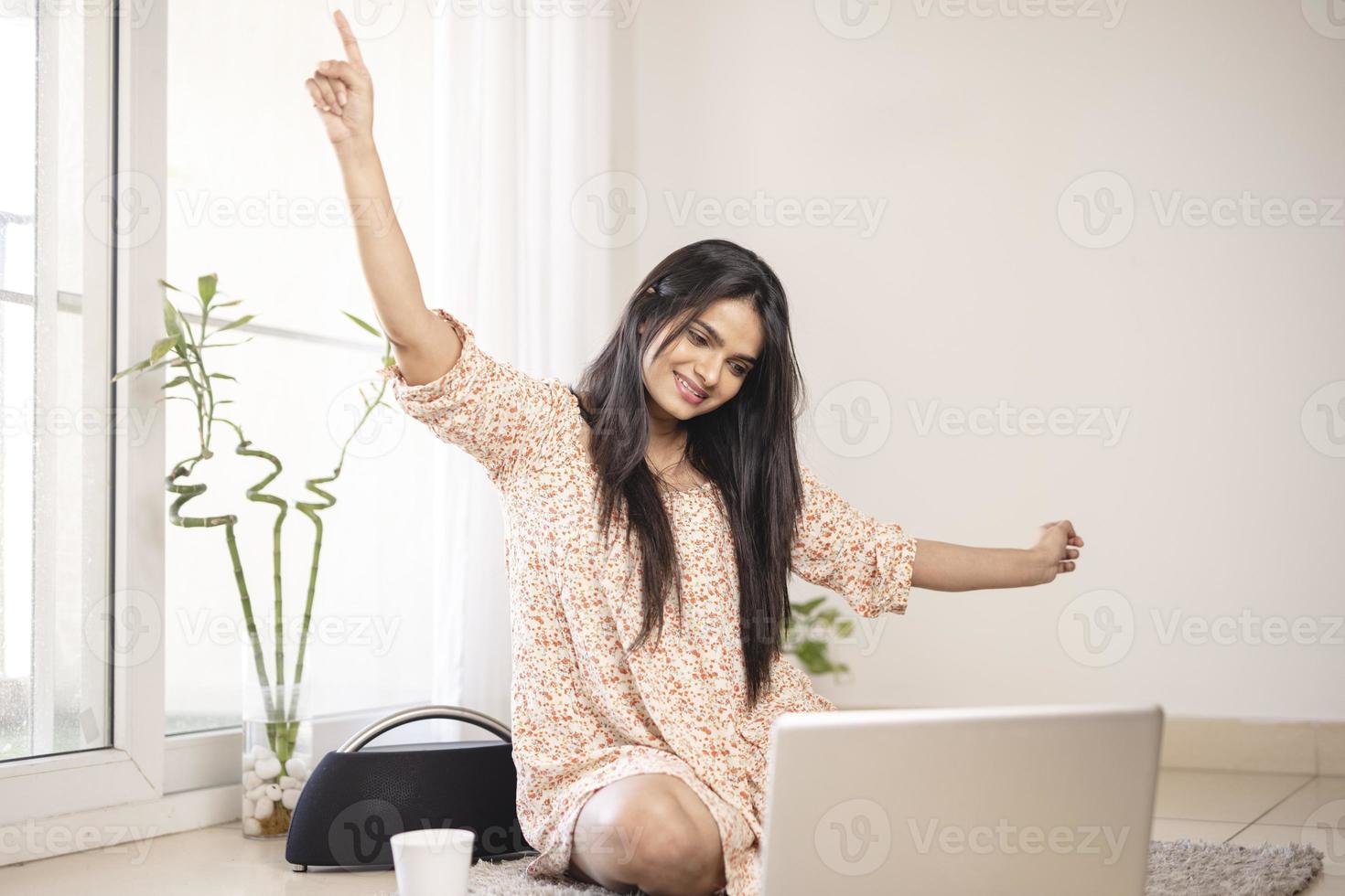 Exited young Indian woman with laptop at home. photo