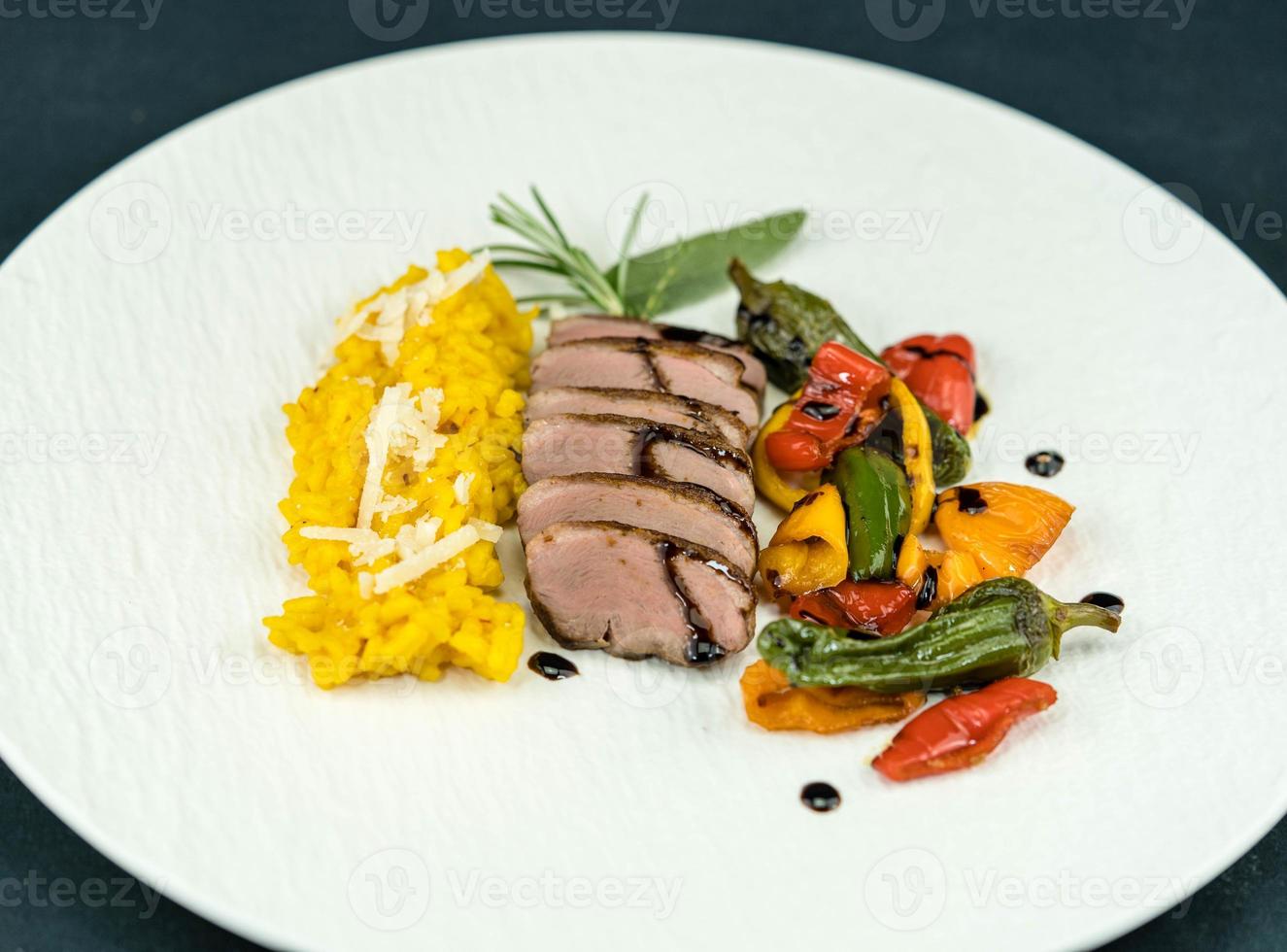 fried Duck breast with saffron risotto photo