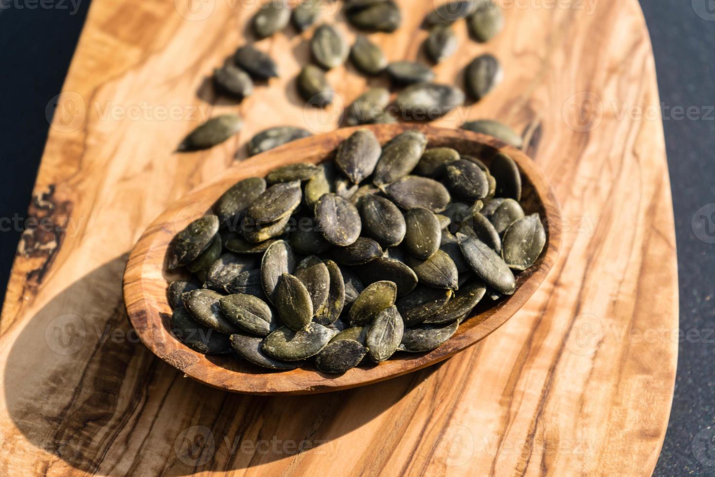 roasted pumpkin seeds on olive wood photo