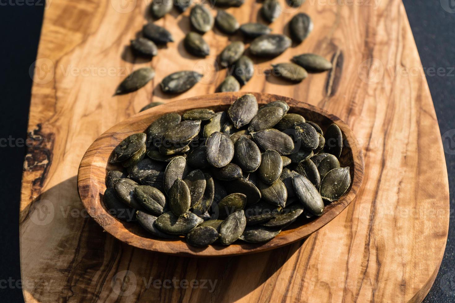 Pipas de calabaza tostadas en madera de olivo foto