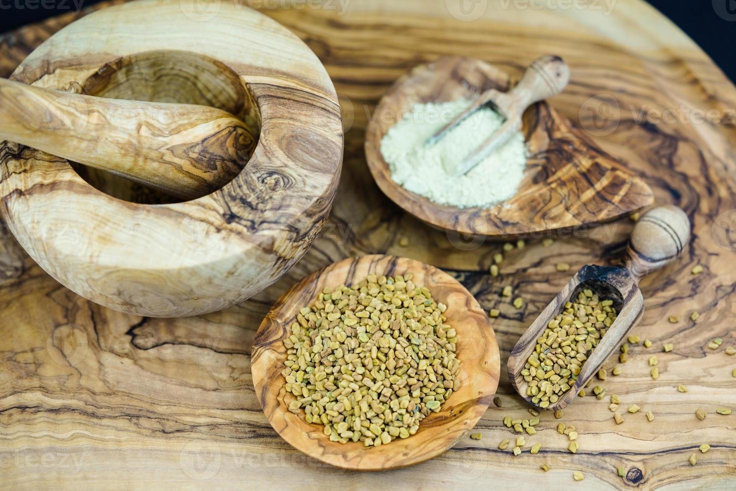 Fenugreek whole or ground on olive wood photo
