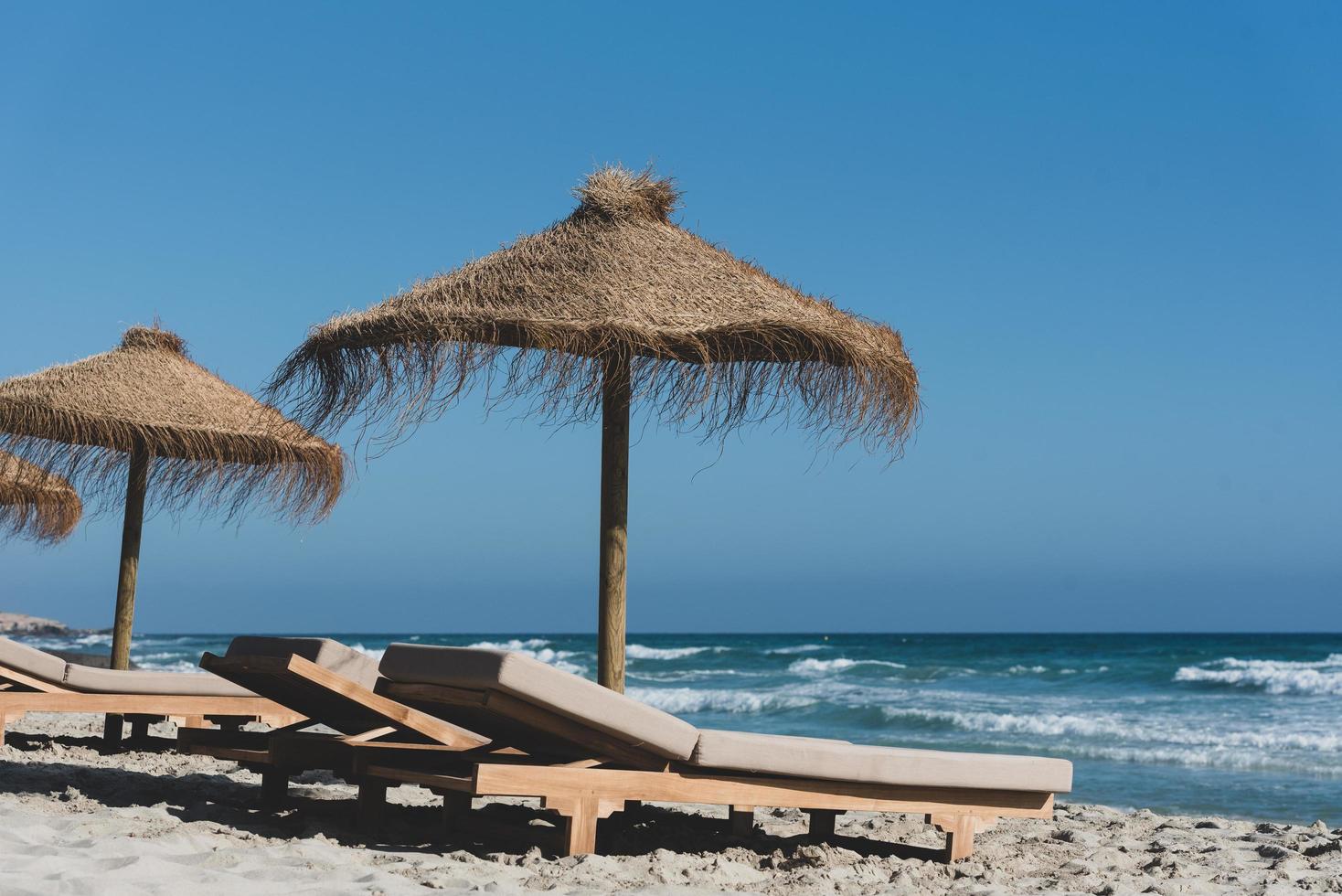 hamacas y sombrillas de paja en la maravillosa isla de formentera foto