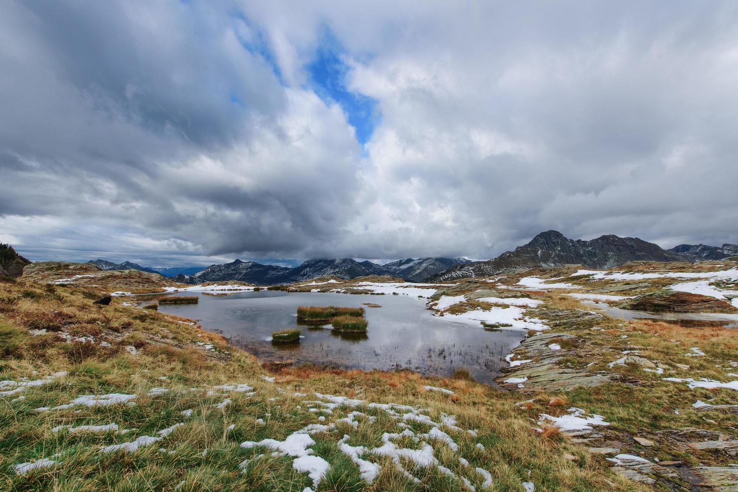 Small alpine lake with meadow islands in autumn photo