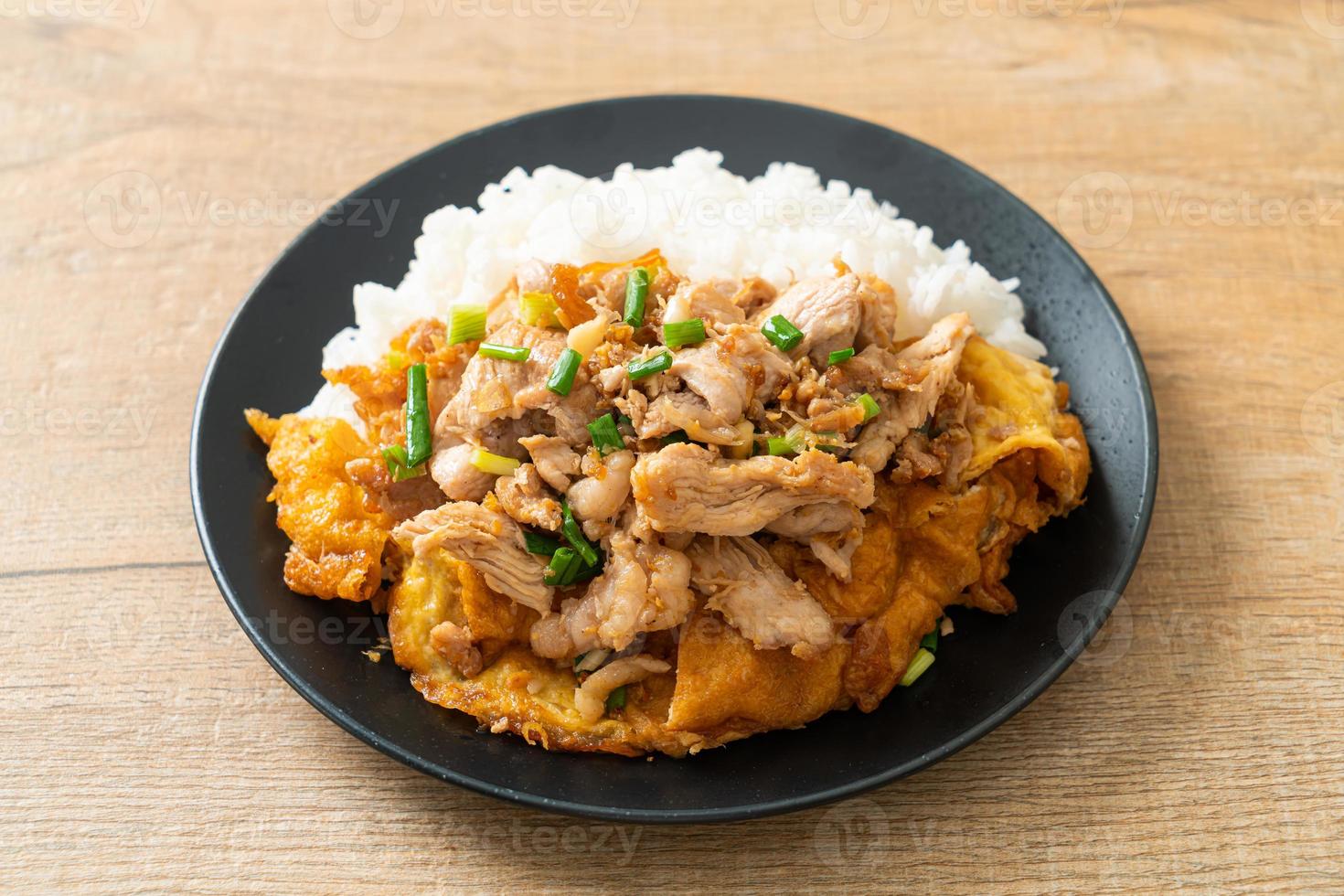 Stir-fried pork with garlic and egg topped on rice - Asian food style photo