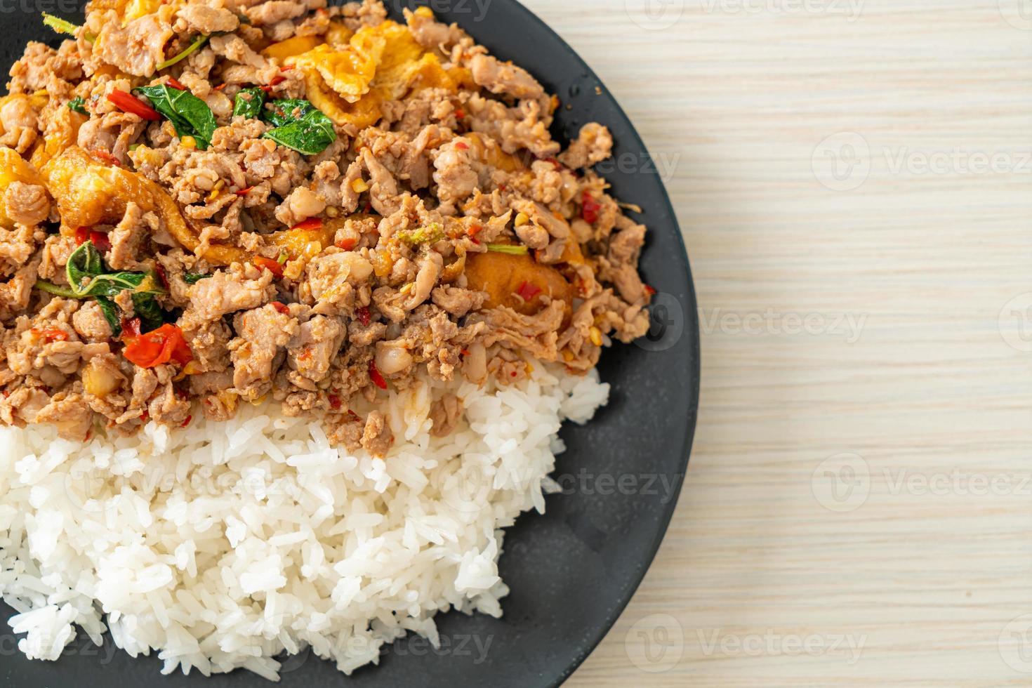 Stir-fried minced pork with basil and egg topped on rice - Asian food style photo