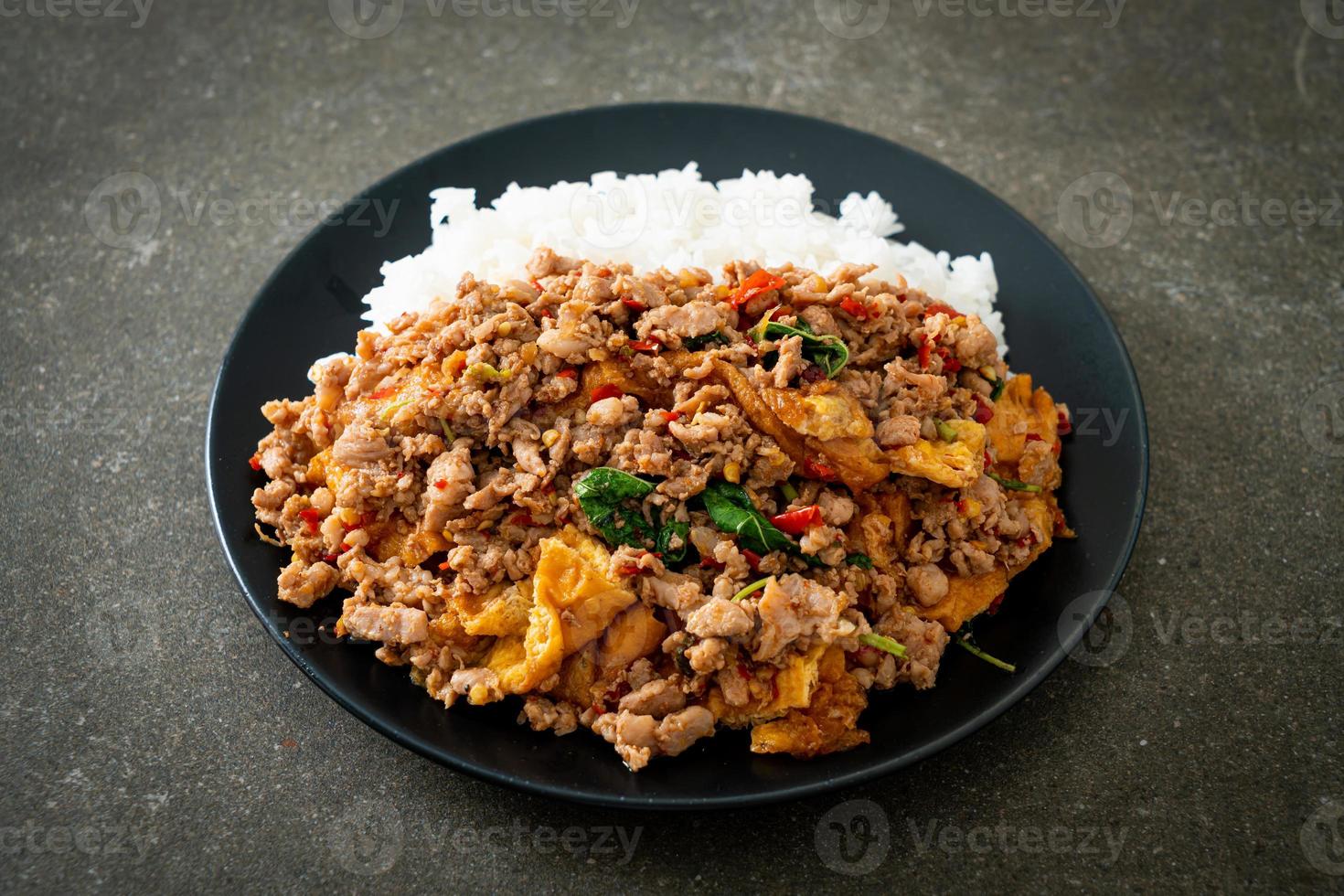 Stir-fried minced pork with basil and egg topped on rice - Asian food style photo