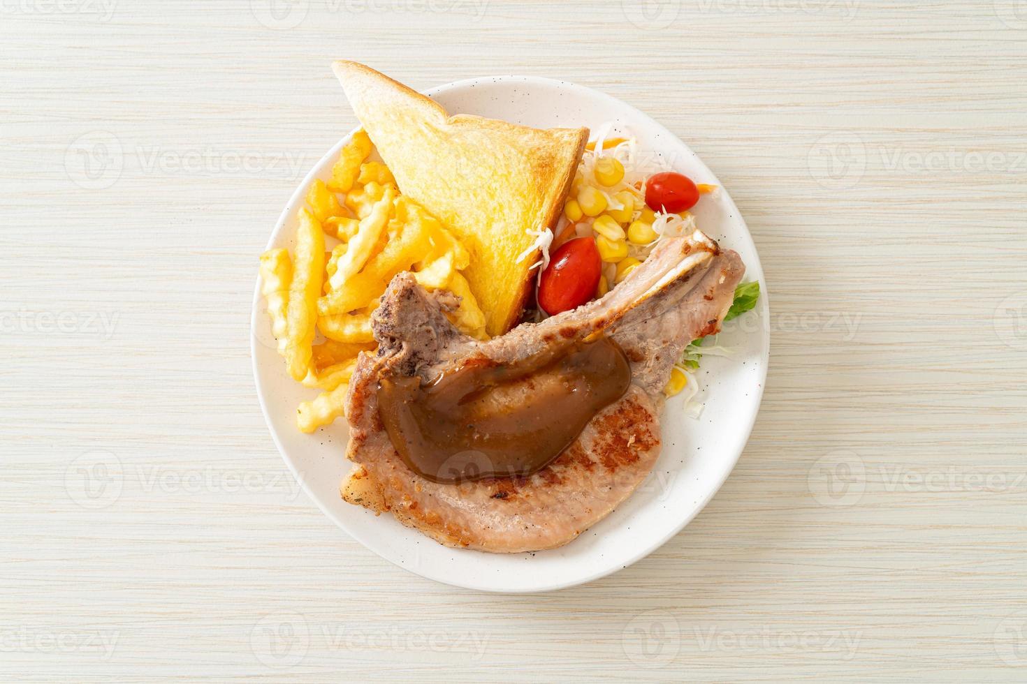 Pork chop steak with chips and mini salad on white plate photo