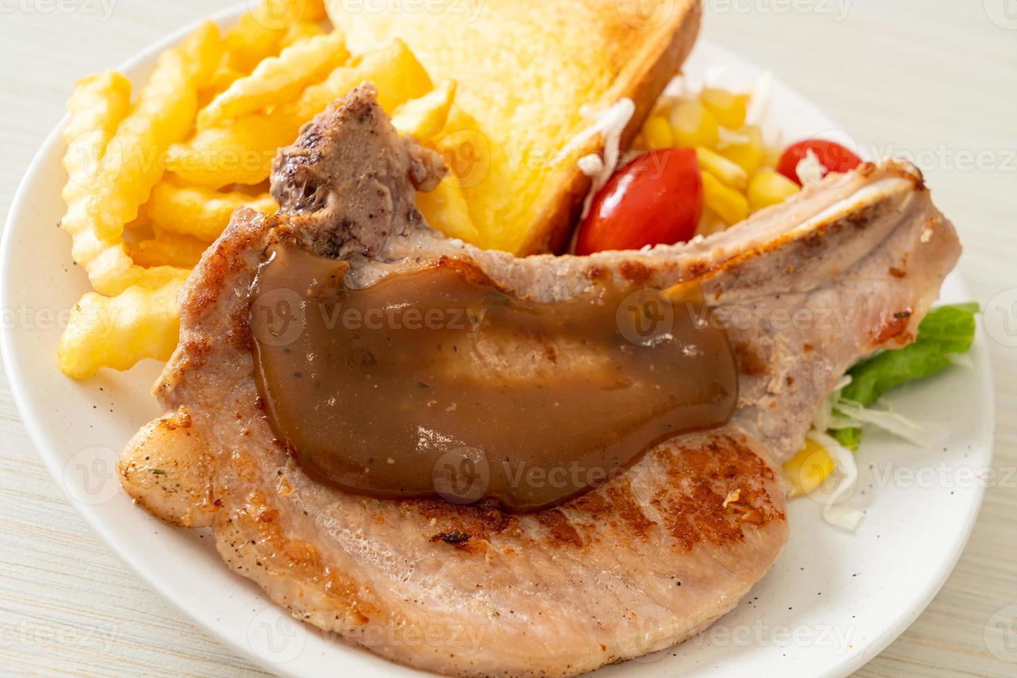 Pork chop steak with chips and mini salad on white plate photo