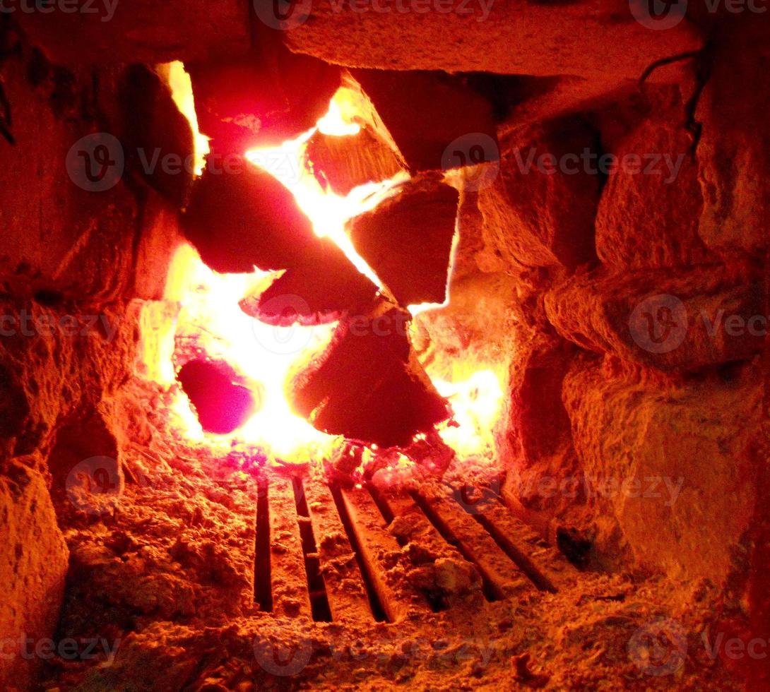 fuego rojo de madera rebanada, carbón negro gris oscuro dentro del brasero de metal foto