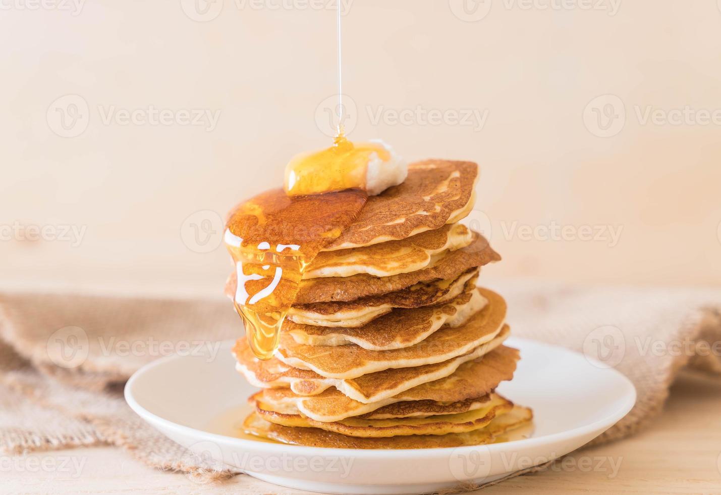 queso en pila de panqueques con miel foto