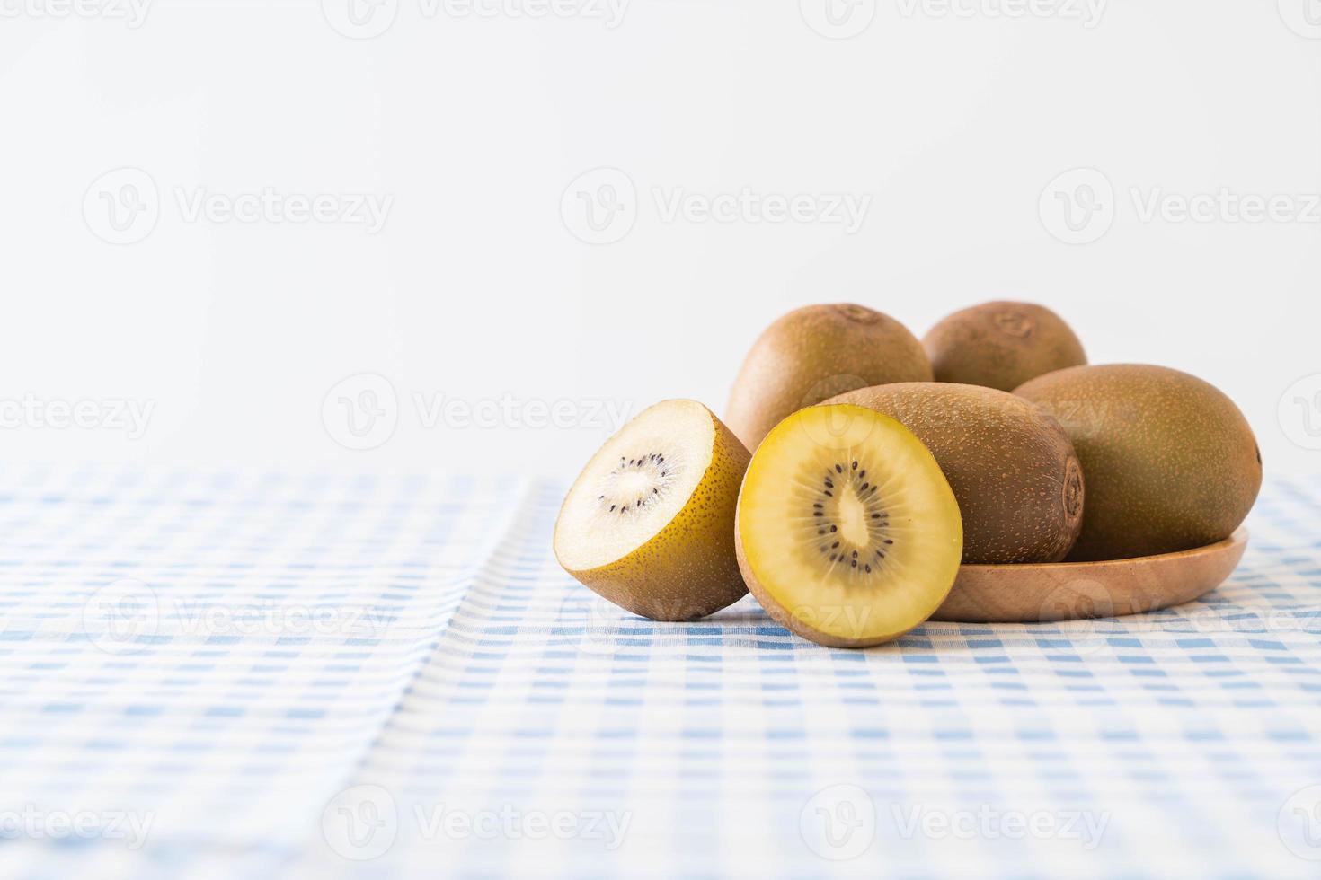 Fresh golden kiwi in wood plate photo