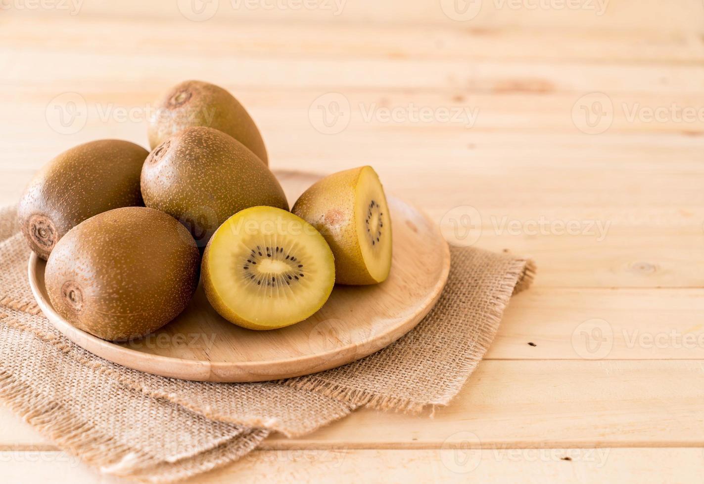 Fresh golden kiwi in wood plate photo