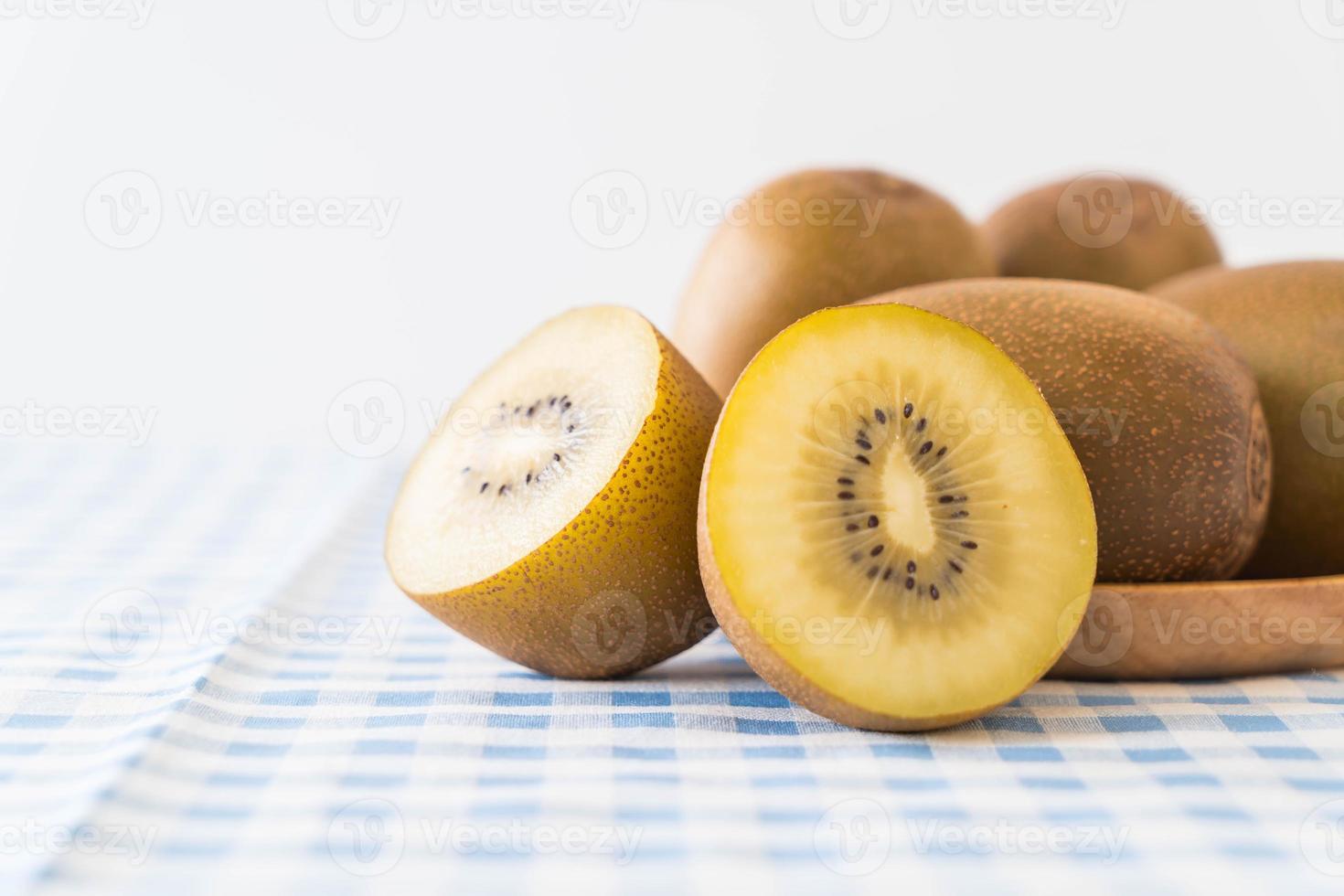 Fresh golden kiwi in wood plate photo