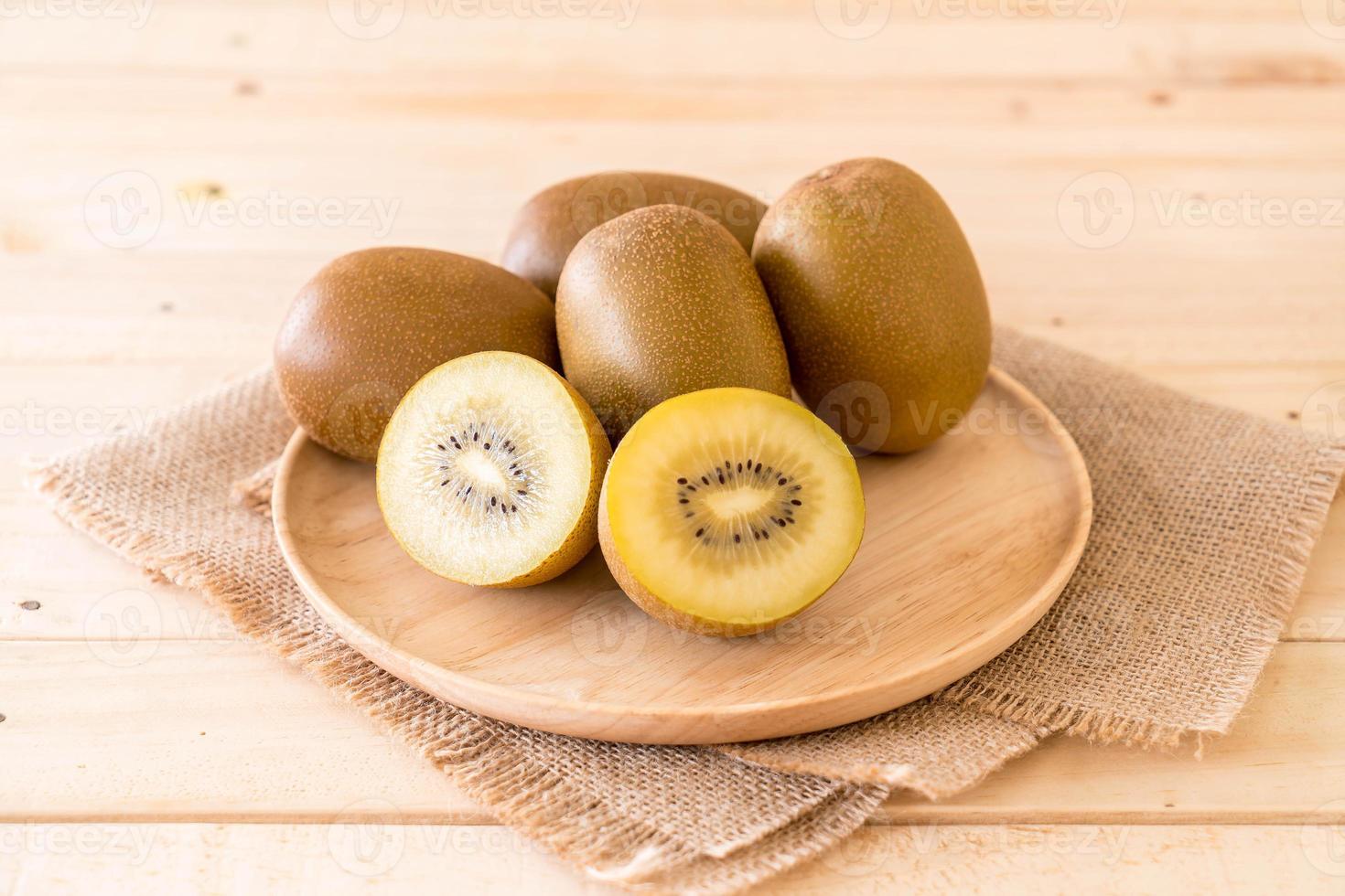 Fresh golden kiwi in wood plate photo