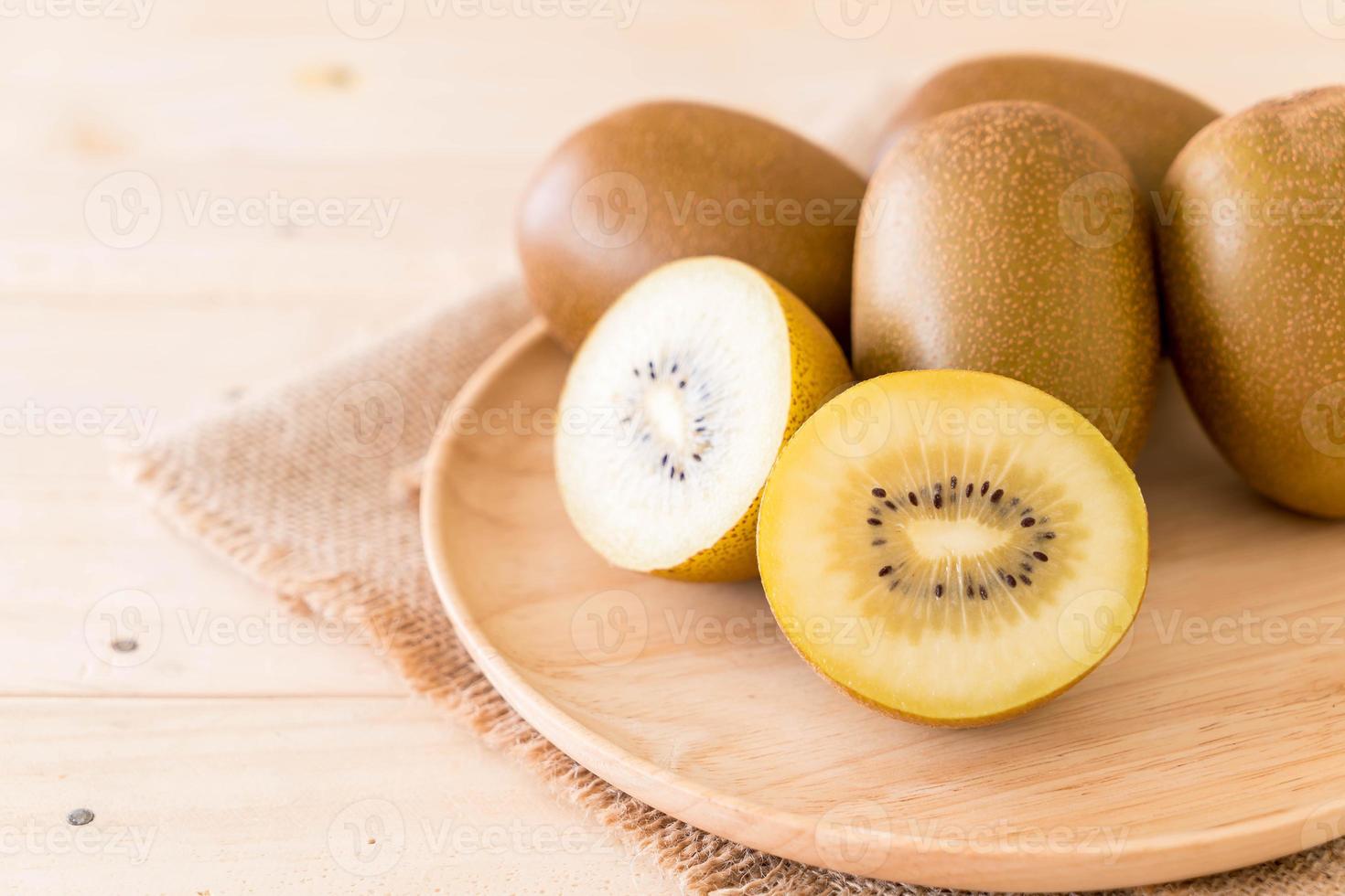 Fresh golden kiwi in wood plate photo