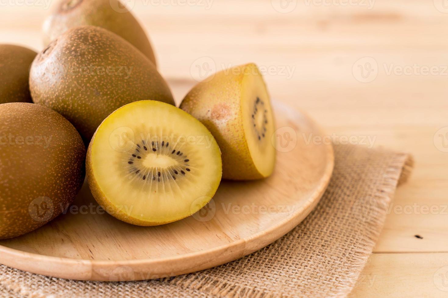 Fresh golden kiwi in wood plate photo