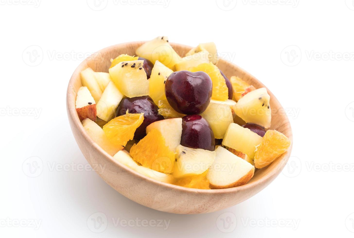 Mixed sliced fruit in wood bowl photo