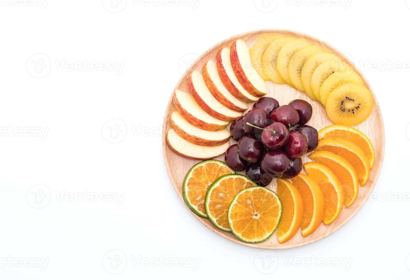 Fruta en rodajas mixtas en un tazón de madera foto