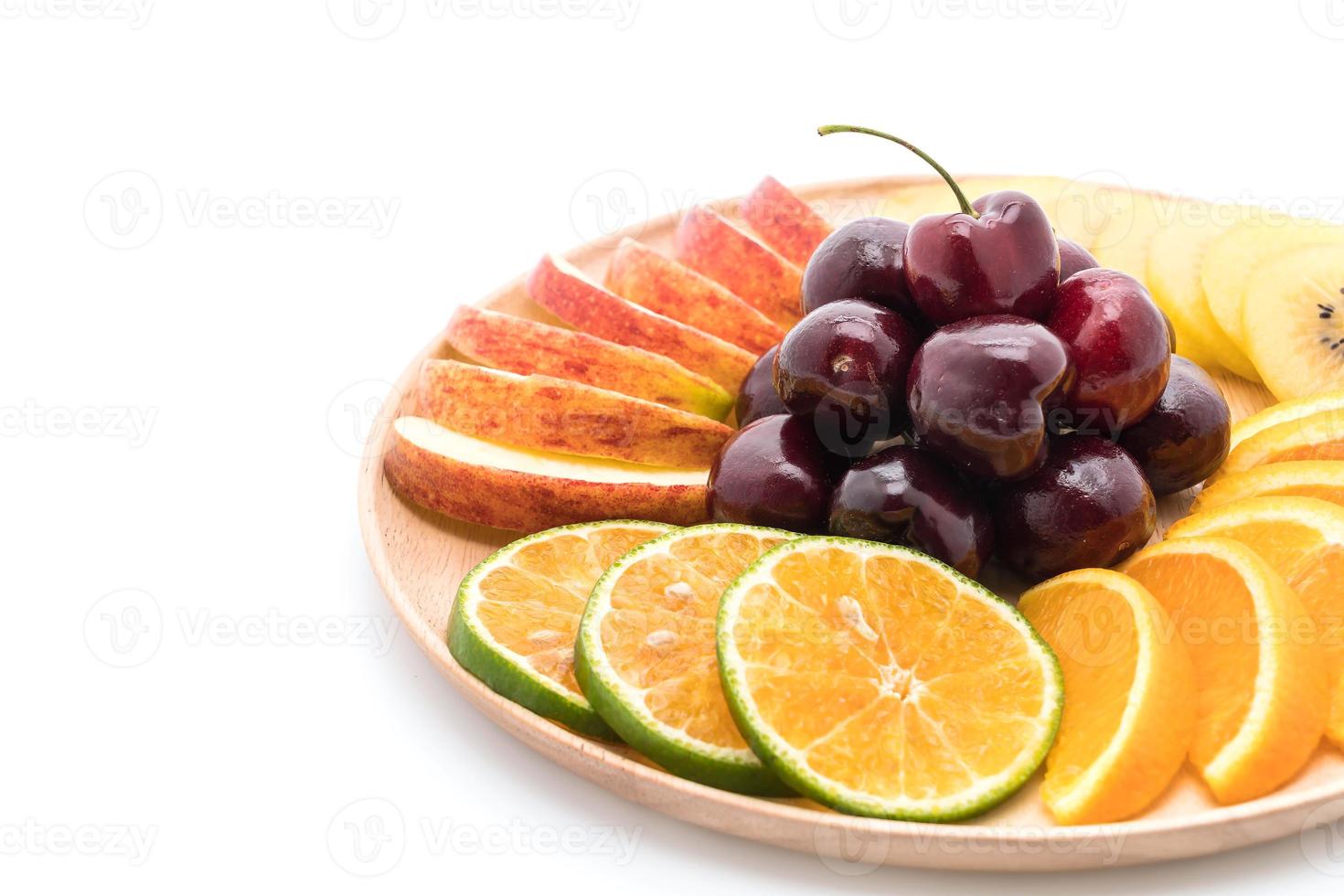 Mixed sliced fruit in wood bowl photo