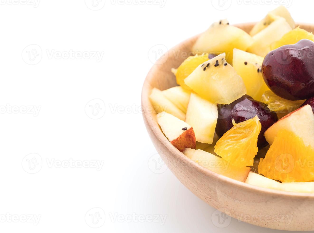 Mixed sliced fruit in wood bowl photo