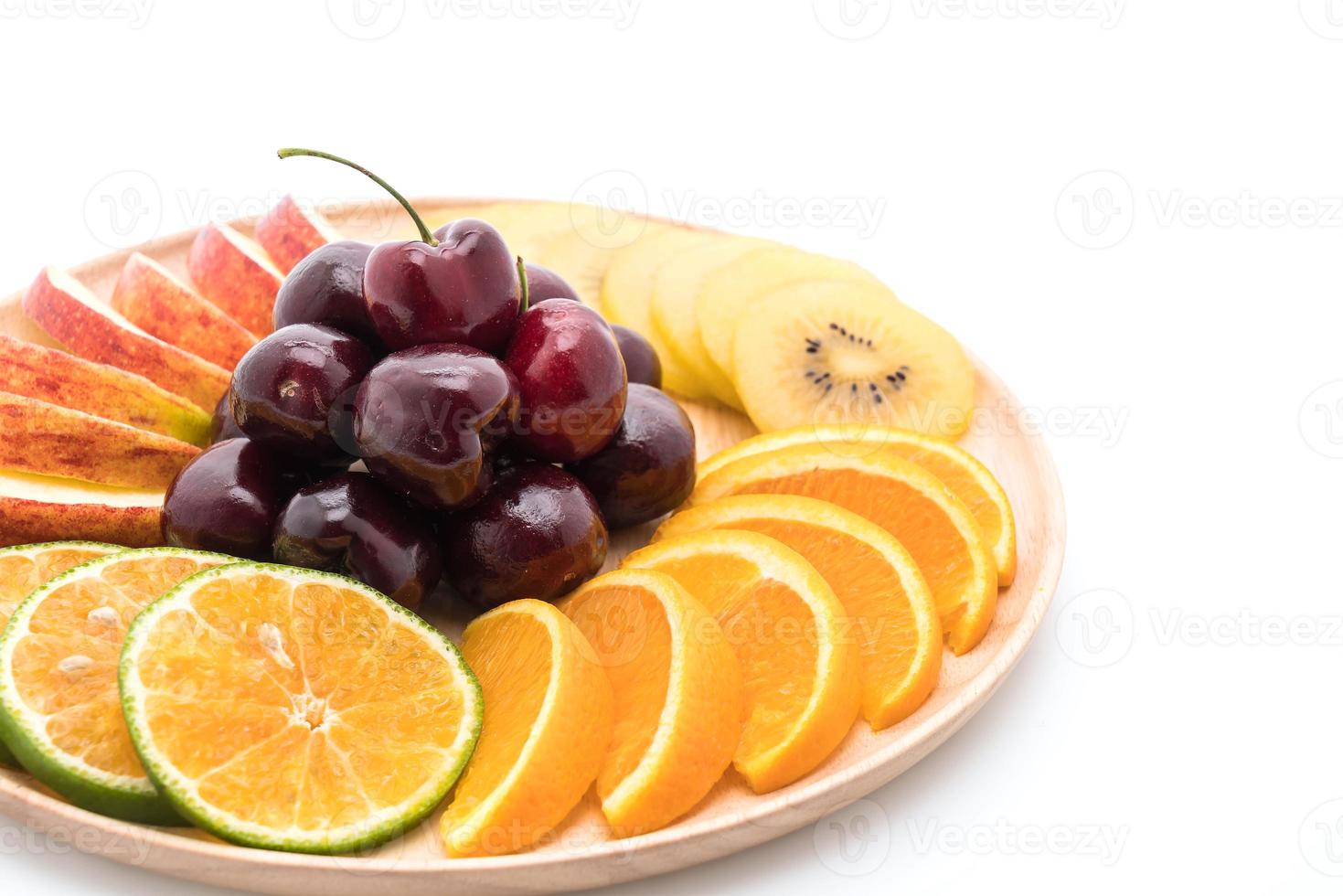 Mixed sliced fruit in wood bowl photo