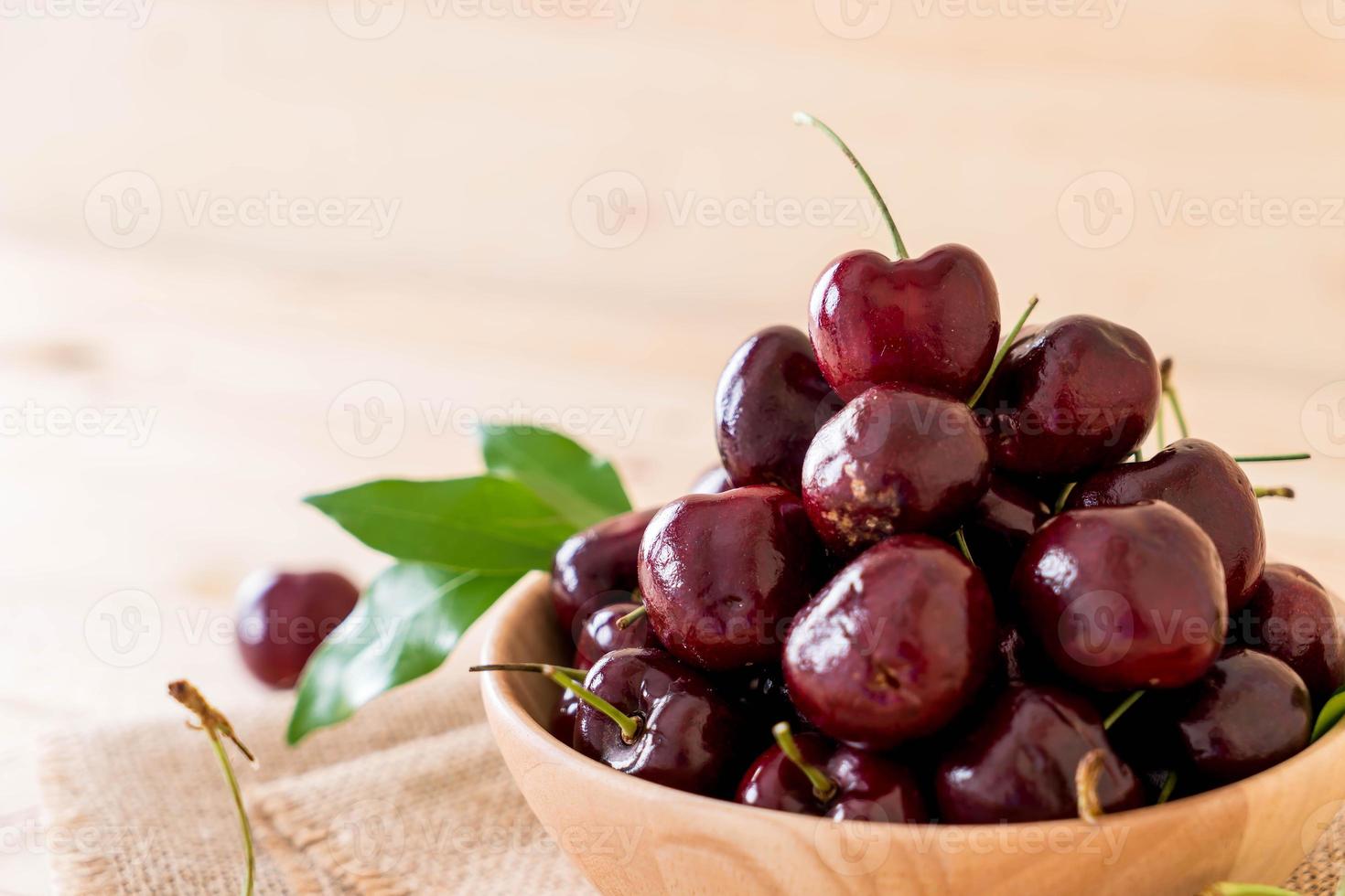 Fresh cherry in wood bowl on the table photo