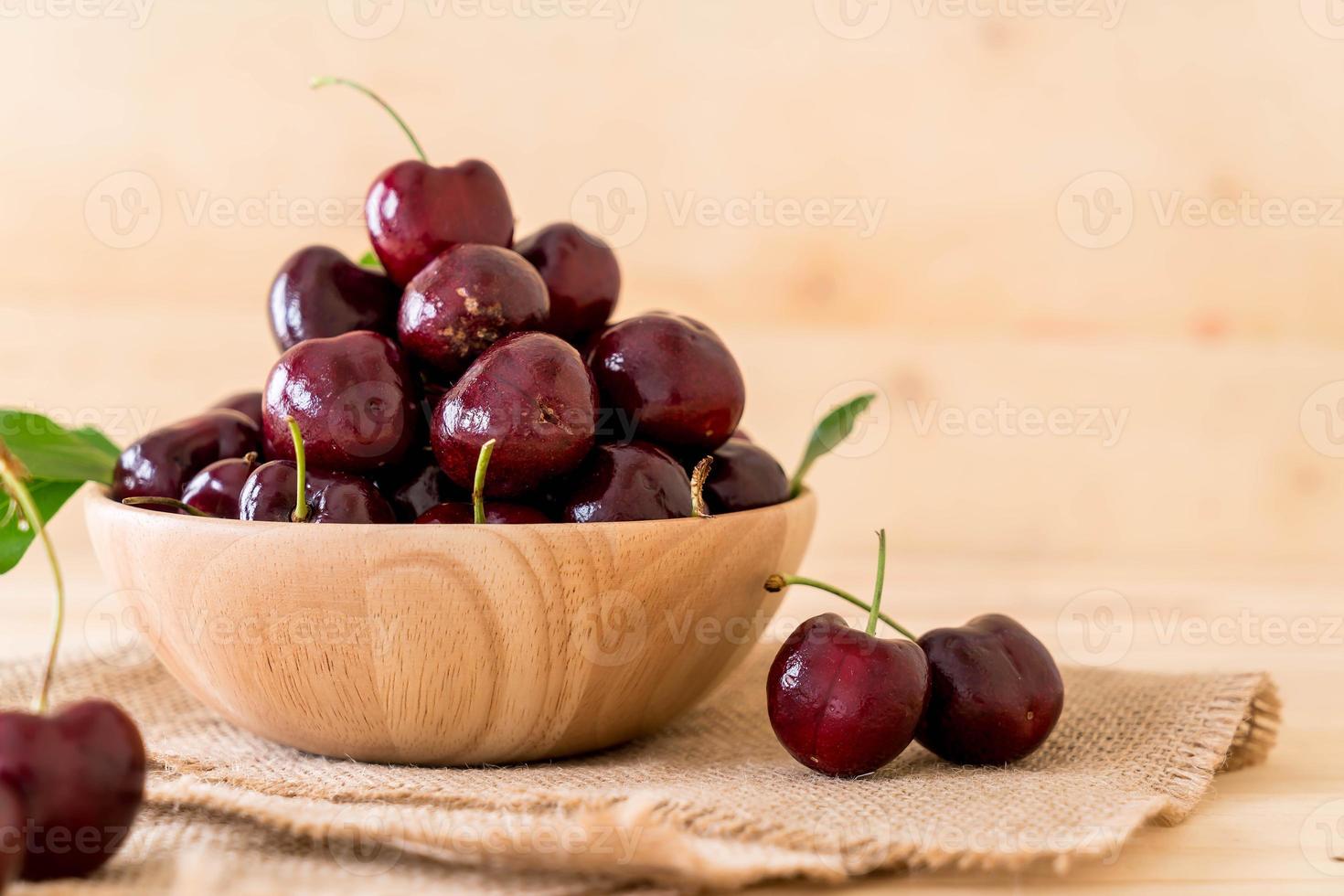 Fresh cherry in wood bowl on the table photo