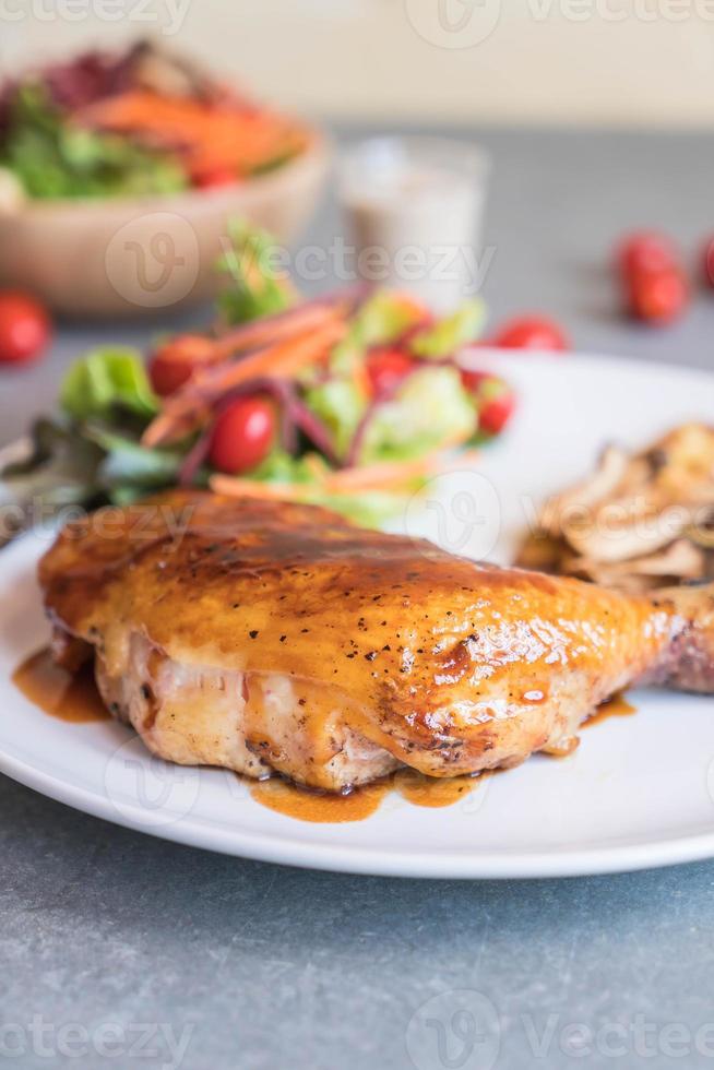 Grilled chicken steak with teriyaki sauce on dining table photo