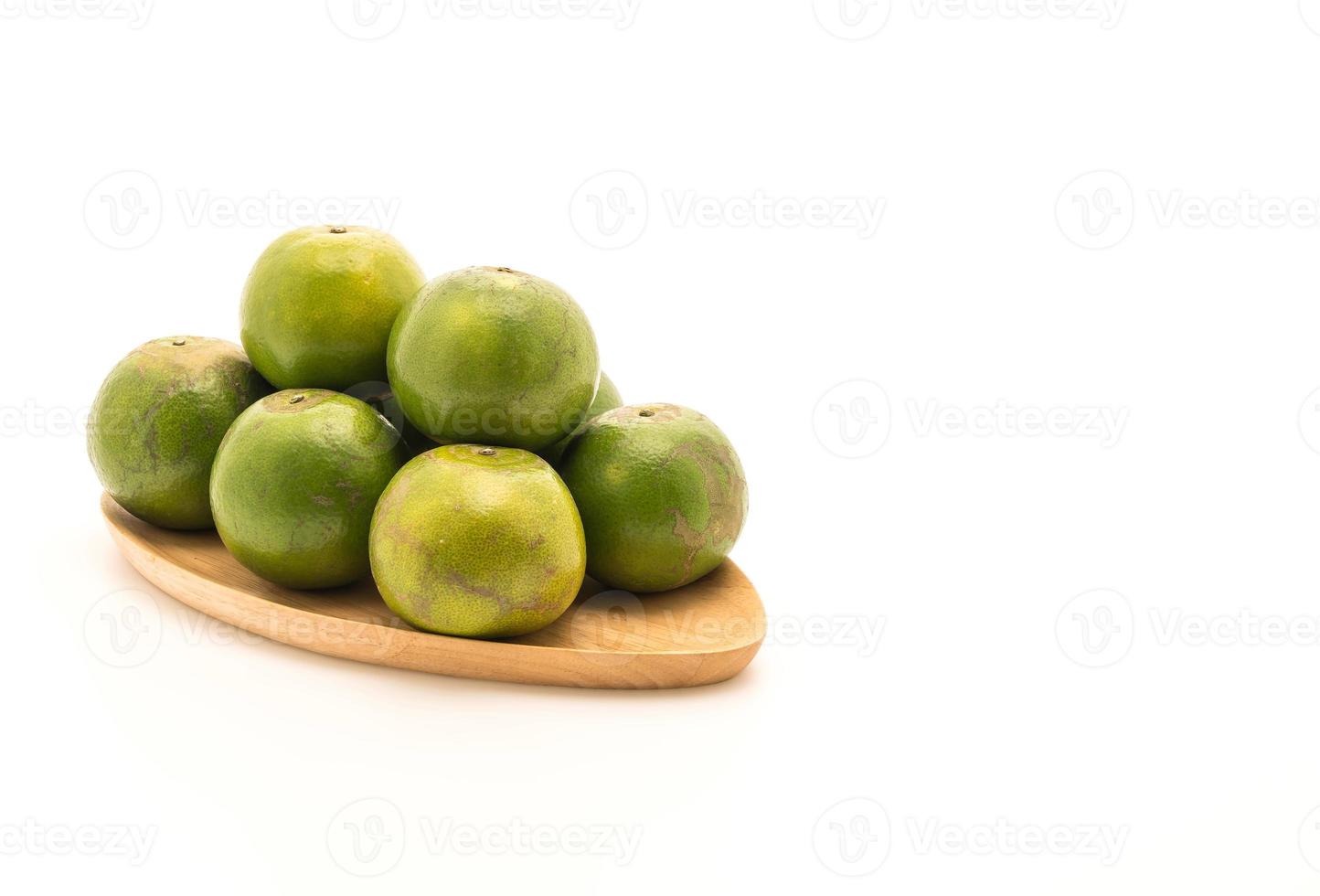 Naranja fresca en placa de madera sobre fondo blanco. foto